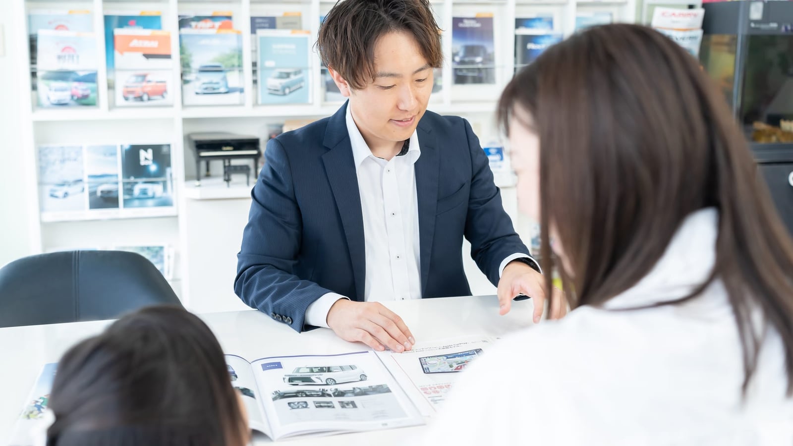 カタログを見ながら車種をご案内する様子